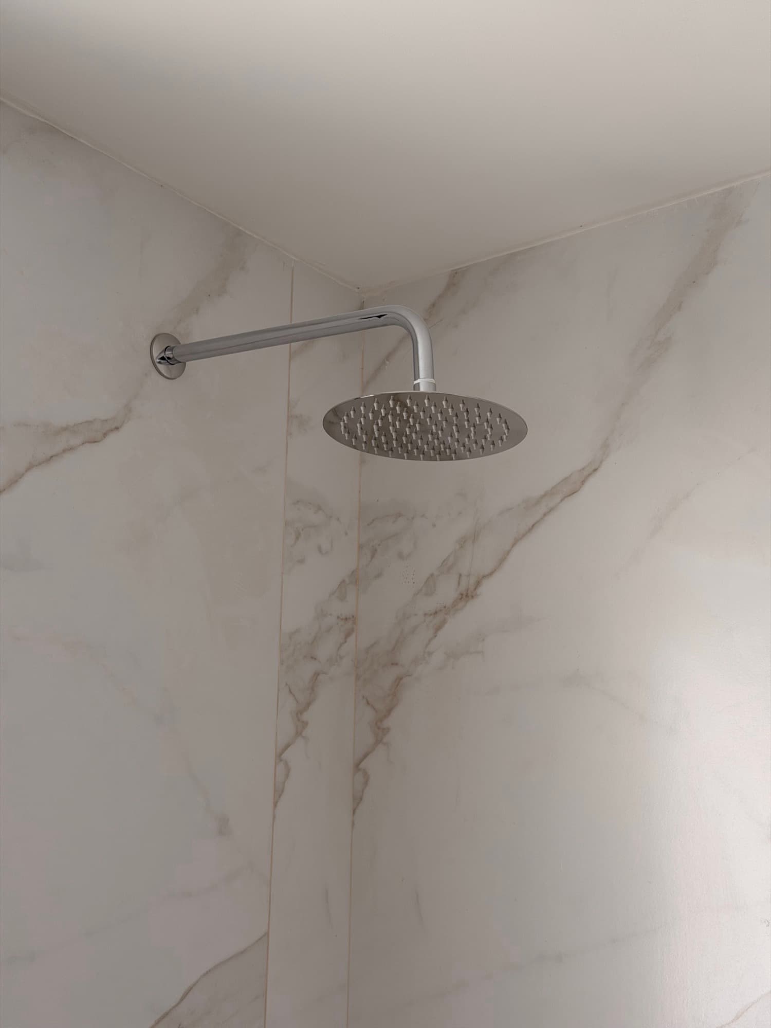 Ducha con lluvia sobre porcelanato símil mármol