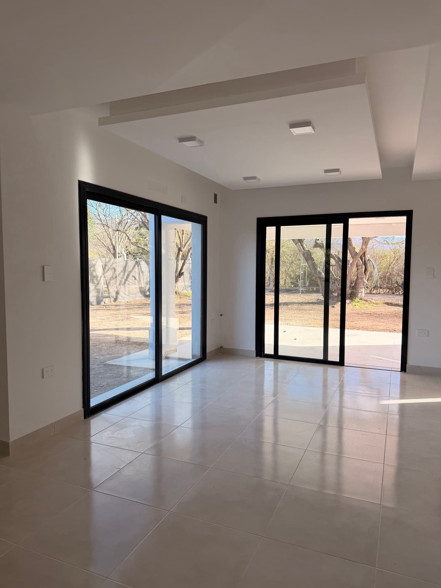 Living-comedor con ventanales corredizos al parque